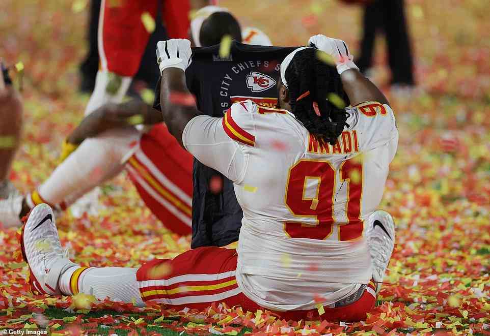Derrick Nnadi (No. 91) of the Chiefs celebrates by falling to the turf as the field is covered in red, yellow and white confetti