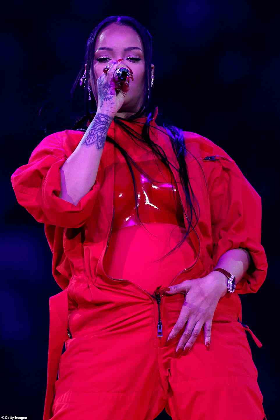 Nothing to hide: Underneath her baggy jumpsuit, Rihanna wore a skin-tight bodysuit that highlighted her burgeoning baby bump. The broadcast included a striking shot of the camera pulling away from her as she rubbed her stomach