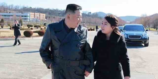 Der nordkoreanische Führer Kim Jong Un (links) und seine Tochter (rechts) gehen zu einer Fotosession mit denjenigen, die am jüngsten Start einer Interkontinentalrakete vom Typ Hwasong-17 an einem unbekannten Ort in Nordkorea beteiligt waren. 
