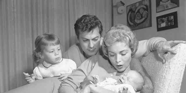 Curtis ist die Tochter der Hollywood-Ikonen Tony Curtis und Janet Leigh.  Janet Leigh hält Jamie Lee Curtis als Baby im Arm, während Jamies ältere Schwester Kelly und Papa Tony Curtis zuschauen.