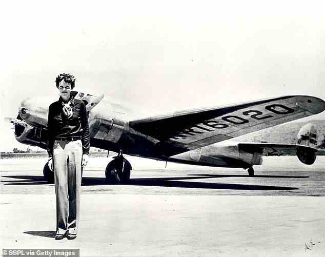 Earhart (born 1897) standing in front of the Lockheed Electra in which she disappeared in 1937