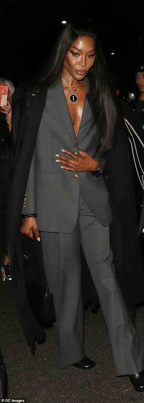 Stilvoll: Naomi sah in einem tiefen grauen Anzug raffiniert aus, während sie sich in einen langen schwarzen Mantel hüllte