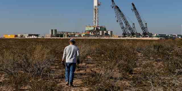 Ein Ölarbeiter geht auf ein Bohrgerät zu, nachdem er am 22. November 2019 in Loving County, Texas, Bodenüberwachungsgeräte in der Nähe des unterirdischen Horizontalbohrers platziert hat.