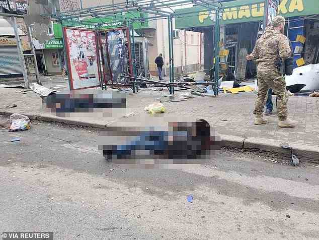 Im Bild: Eine verletzte Person (Mitte) ist am Boden in der Nähe der Stelle zu sehen, an der am Dienstag eine russische Rakete Cherson getroffen hat.  Links ist die Leiche eines Streikopfers zu sehen