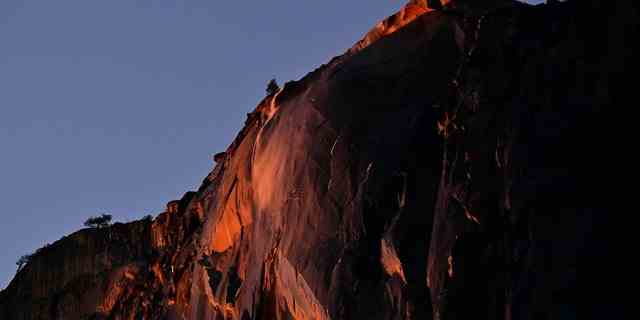 Wasser, das aus dem Schachtelhalm-Fall fließt, leuchtet orange, während es von der untergehenden Sonne während der Hintergrundbeleuchtung beleuchtet wird "Feuerfall" Phänomen im Yosemite-Nationalpark, Kalifornien, am 15. Februar 2023. 
