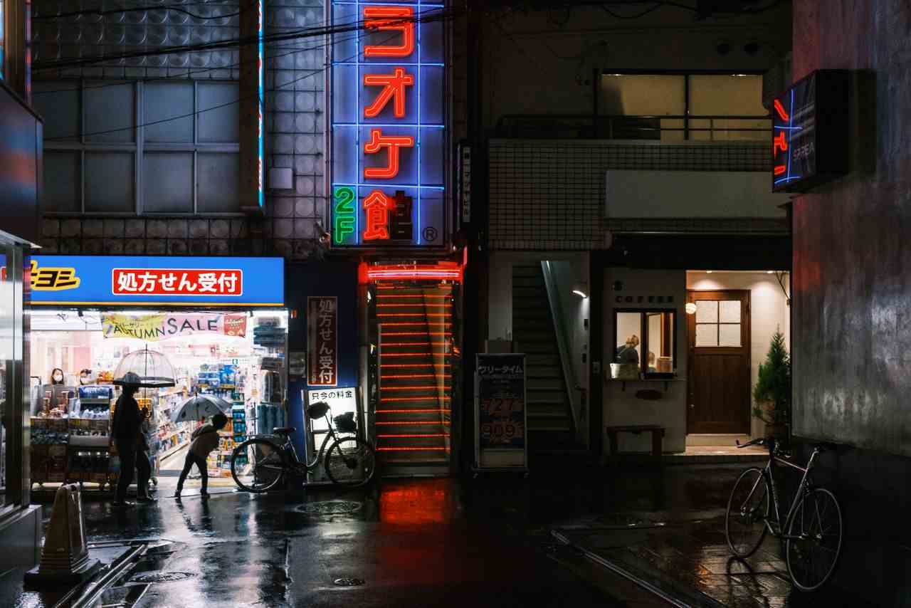 A pharmacy, karaoke hall and hair salon at night in Shimokitazawa, Tokyo.