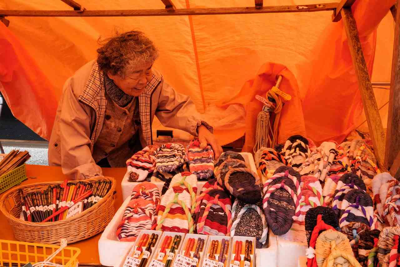 A woman sells handmade cloth sandals at the Wajima Morning Market on Noto Peninsula.