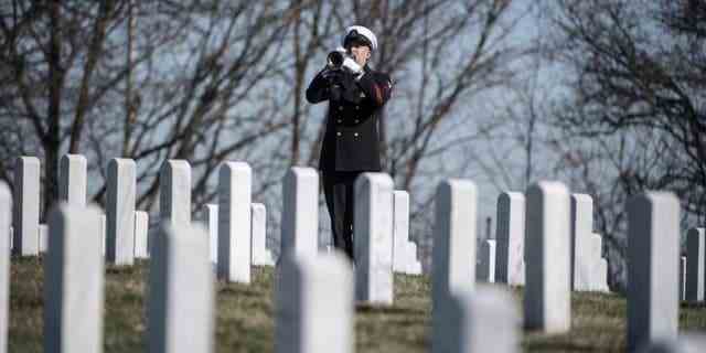 Ein Trompeter der US Navy Ceremonial Band spielt "Hähne" während der militärischen Begräbnisehrungen für US Navy Gunner's Mate 3rd Class Herman Schmidt in Abschnitt 70 des Arlington National Cemetery in Arlington, Virginia, 23. Februar 2023. 