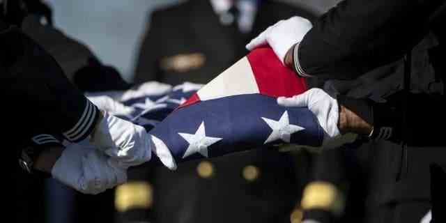 Matrosen der US Navy Ceremonial Guard und der US Navy Ceremonial Band führen am 23. Februar 2023 in Abschnitt 70 des Arlington National Cemetery in Arlington, Virginia, militärische Bestattungsehren für US Navy Gunner's Mate 3rd Class Herman Schmidt durch.