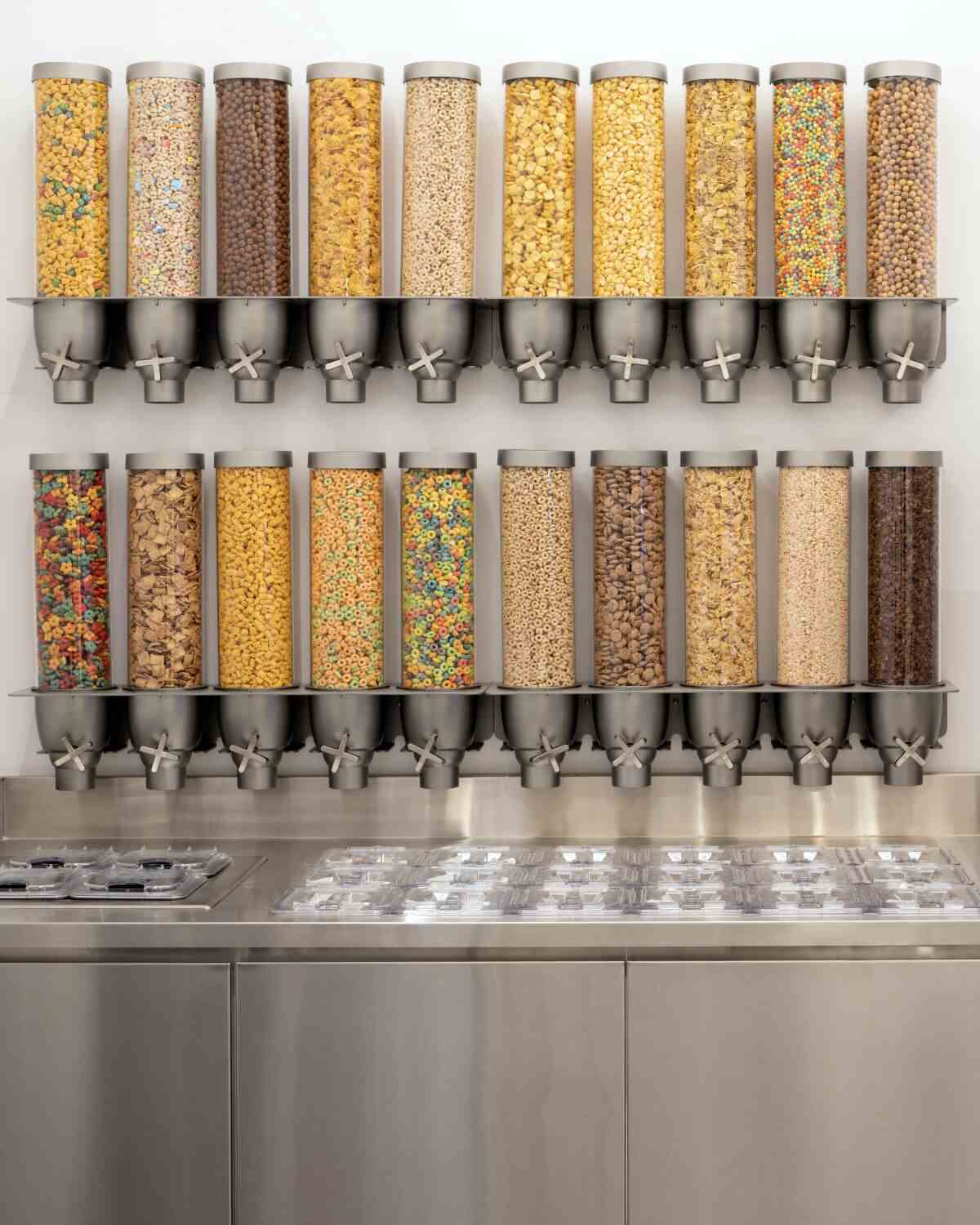 Ein vertikales Foto von Kith Treats Reihen von Müslispendern aus durchsichtigem Kunststoff für seinen Softeis.