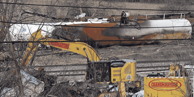 Arbeiter werden am Dienstag, den 21. Februar gesehen, wie sie nach der Güterzugentgleisung von Norfolk Southern am 3. Februar entgleiste Waggons in Ostpalästina, Ohio, säubern. 