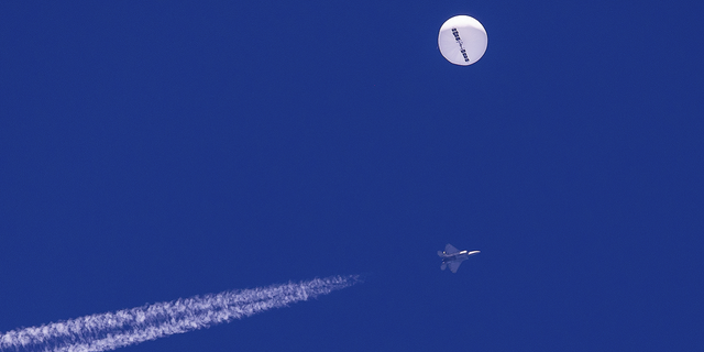 Auf diesem von Chad Fish bereitgestellten Foto schwebt am Samstag, dem 4. Februar, ein großer Ballon über dem Atlantik, direkt vor der Küste von South Carolina, mit einem Kampfjet und seinem Kondensstreifen darunter.