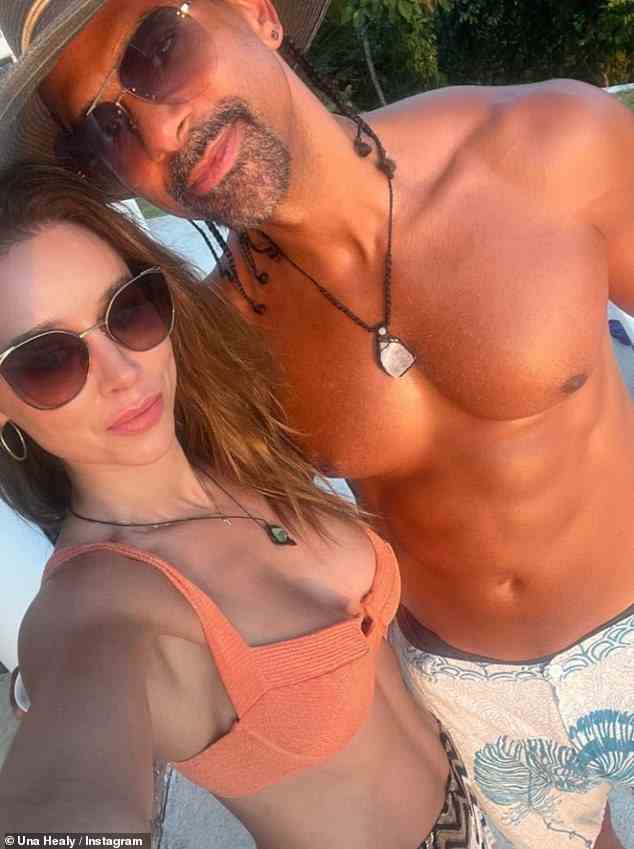 Loved-up: Una Healy looked on cloud nine as she cosied up to David Haye on the beach in Costa Rica after he appeared to confirm they are in a 'throuple' with Sian Osborne