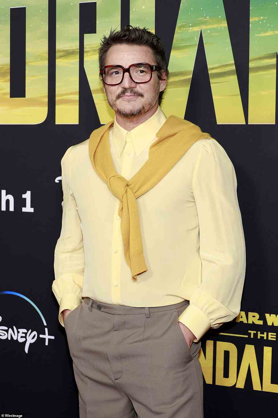 Preppy: Pascal cut a preppy figure as he tied a mustard cardigan around the shoulders of his pastel yellow button-up shirt