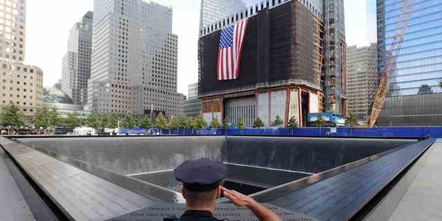 New Yorker Polizist grüßt am 9/11 Memorial in New York City. 