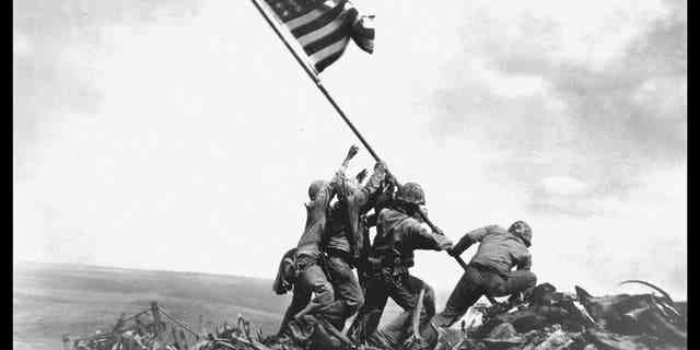 Ansicht von Mitgliedern der 5. Division des United States Marine Corps, während sie während der Schlacht von Iwo Jima am 23. Februar 1945 eine amerikanische Flagge auf dem Berg Suribachi hissen. 
