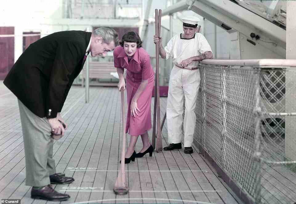 A couple plays a deck game with a Cunard member of staff in this undated archive snapshot