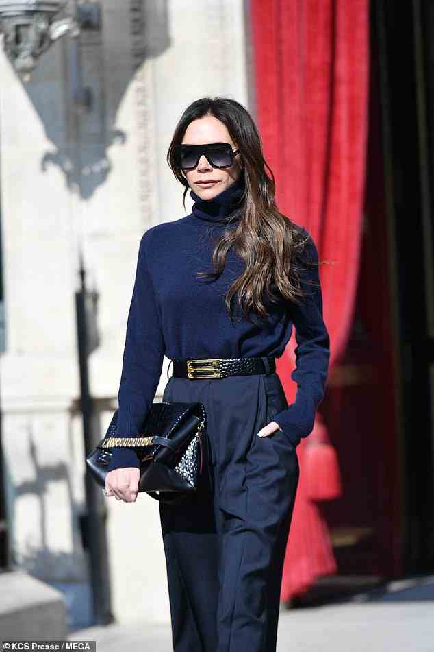Stylish: The designer oozed business chic in a pair of navy tailored trousers and a complementing turtle-neck jumper