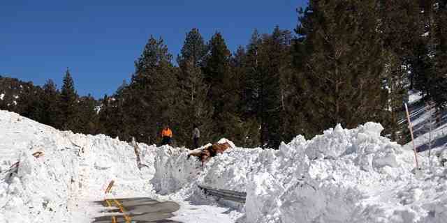 Caltrans-Mitarbeiter untersuchen die Schäden, die durch eine Lawine auf der California State Route 38 nach einer Reihe von Schneestürmen am 2. März 2023 in der Nähe von Big Bear, Kalifornien, verursacht wurden. 