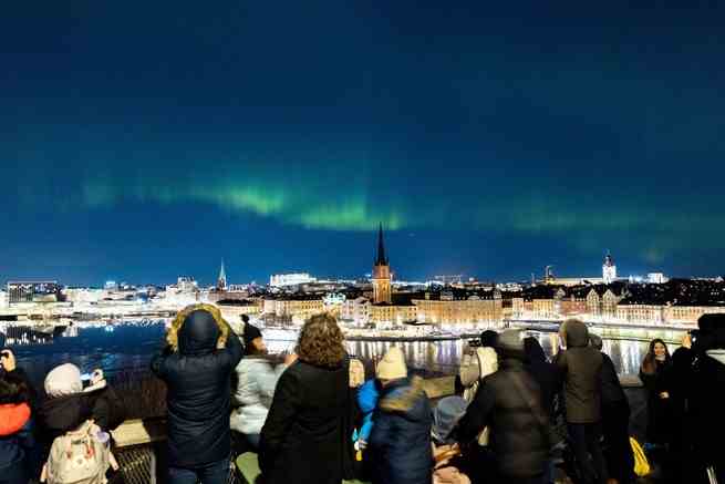 Menschen beobachten am 27. Februar 2023 die Nordlichter über dem Zentrum von Stockholm, Schweden. 