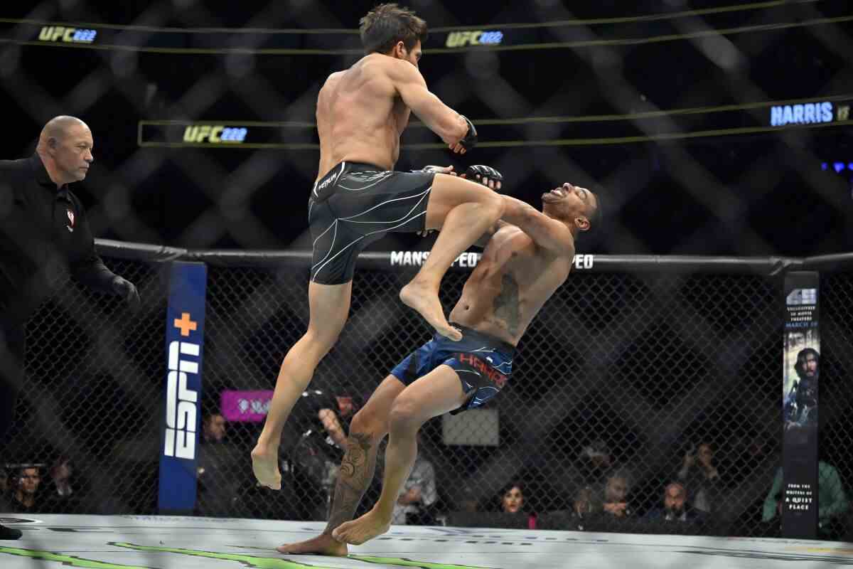Ein Mann springt in einem Kampfring über einen anderen Mann