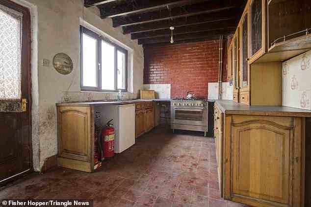 Fotos zeigen Anzeichen von Feuchtigkeit in der Immobilie an den Wänden - hier ist die Küche abgebildet