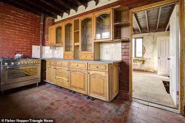 Rostige Küchenschränke mit rustikalen Wänden, die gestrichen werden müssen
