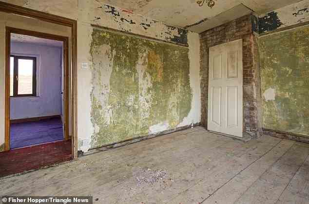 Wände blättern ab und Staub auf dem Boden, da das Haus mit Aussicht auf Renovierung zum Verkauf steht