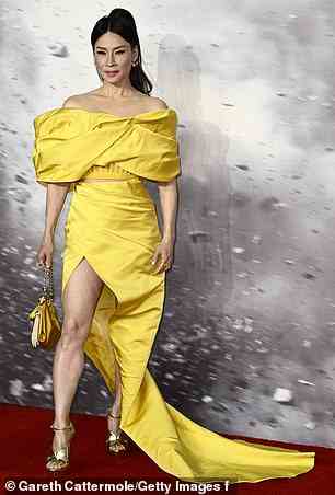 Fashion forward: Lucy, who plays Kalypso in the film, cut a very glamorous figure as she posed in her canary yellow gown-