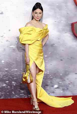 Fashion forward: Lucy, who plays Kalypso in the film, cut a very glamorous figure as she posed in her canary yellow gown