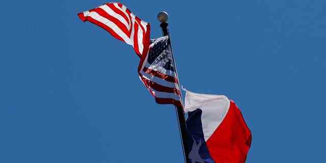 Die US-Flagge und die Flagge des Staates Texas wehen über dem Texas State Capitol