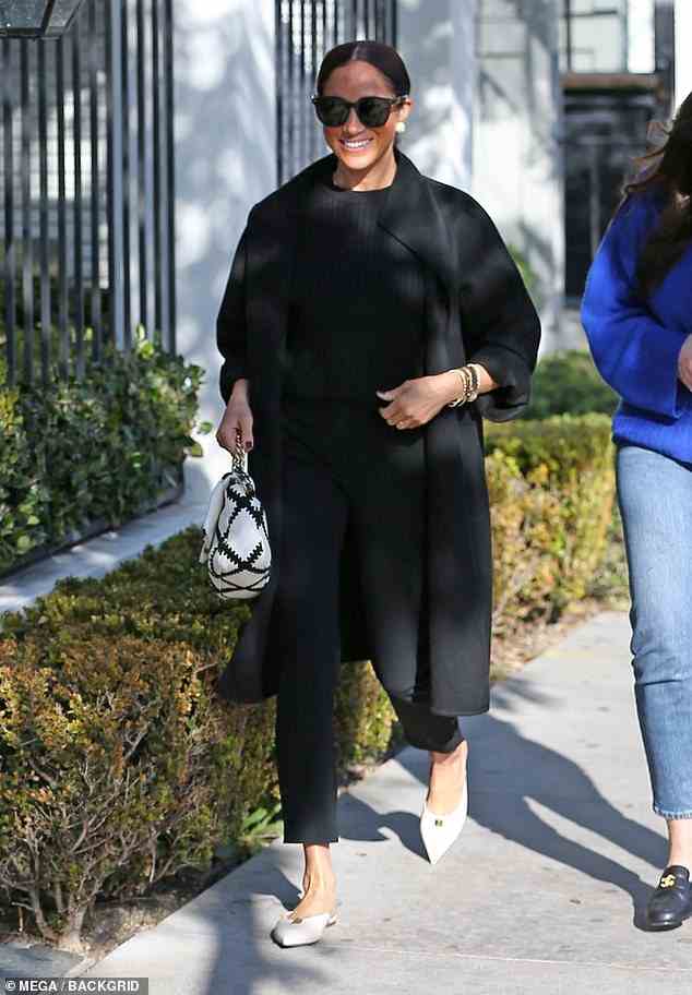 Meghan Markle smiles as she is photographed outside the restaurant in California yesterday