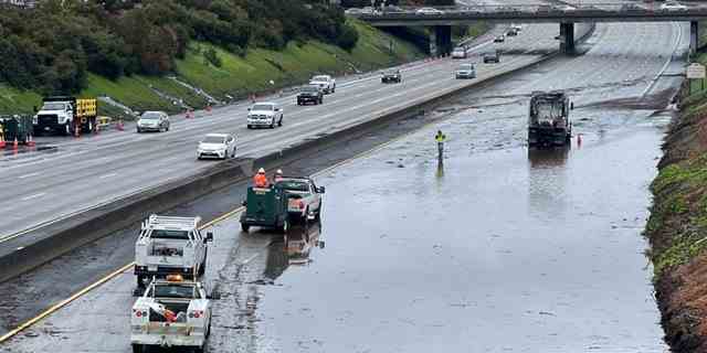 Caltrans-Crews arbeiten am Freitag, den 10. März 2023, an einem überfluteten Abschnitt der Interstate 580 in Oakland, Kalifornien. Ein neuer atmosphärischer Fluss hat starken Regen und Gewitter nach Kalifornien gebracht, was zu Überschwemmungsgefahren und Reiseunterbrechungen geführt hat.