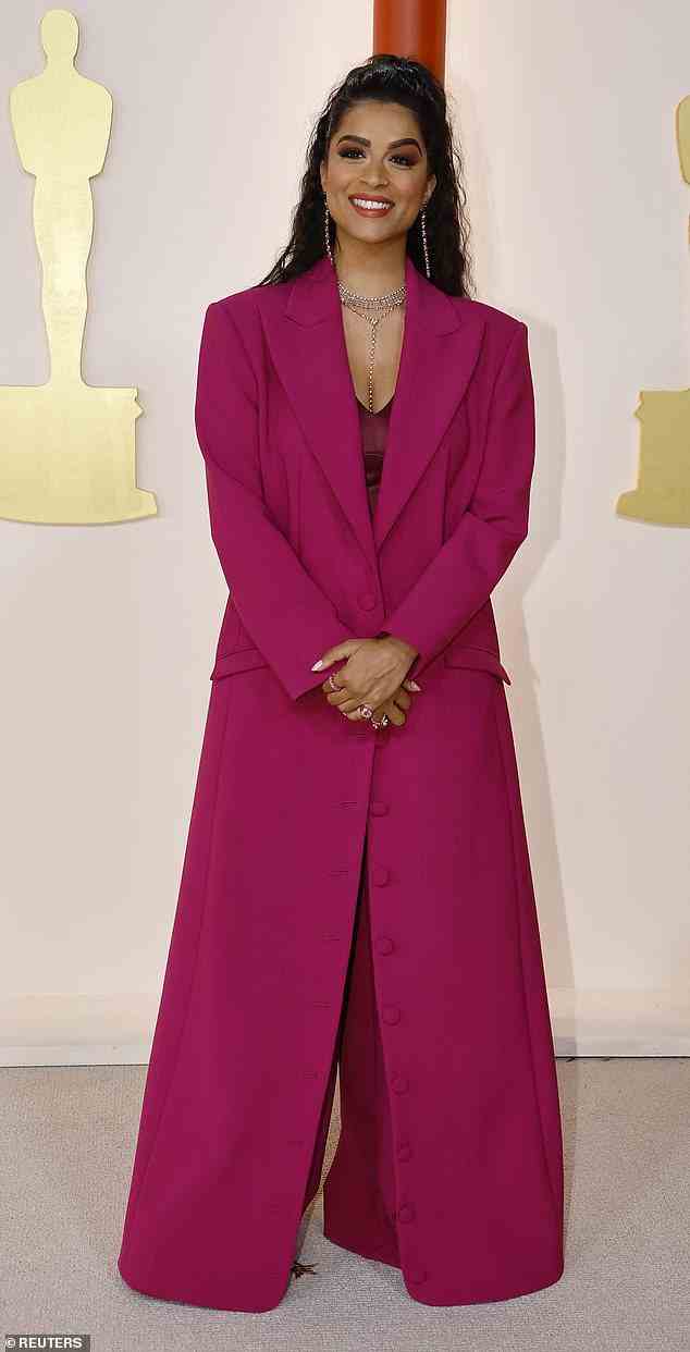 Bizarre look: Popular YouTuber Lilly Singh, 35, wore a questionable outfit to the 2023 Oscars, donning a bright pink floor-length trench coat and clunky boots