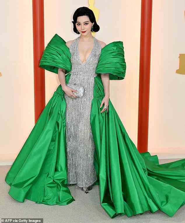 Too much: Chinese actress Fan Bingbing, 41, wore for a sparkly, silver, haltered gown - which she paired with a huge, bright green scarf that ensured all eyes would be on her