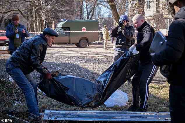 Communal service personnel remove the body of a victim from the scene following a Russian missile strike on a residential building in Kramatorsk, Donetsk region, Ukraine, on Tuesday