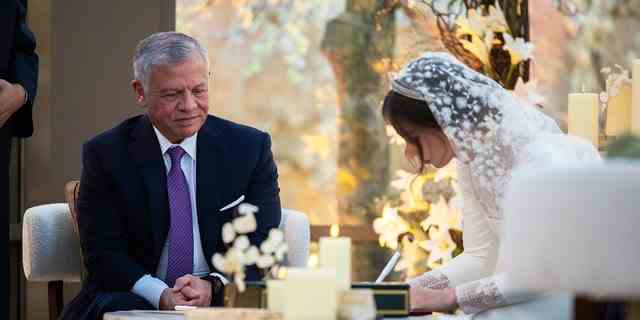 König von Jordanien, Abdullah II., sieht zu, wie seine Tochter während der Zeremonie die Hochzeitsurkunde unterzeichnet.