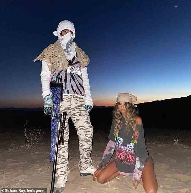 Sahara zog im März 2020 auch die Augenbrauen hoch, nachdem sie zwei Fotos von sich selbst gepostet hatte, wie sie in einem G-String und einem T-Shirt in der Wüste kniete.  Hinter ihr stand ein maskierter Mann, der den Lauf eines Gewehrs in den Sand drückte