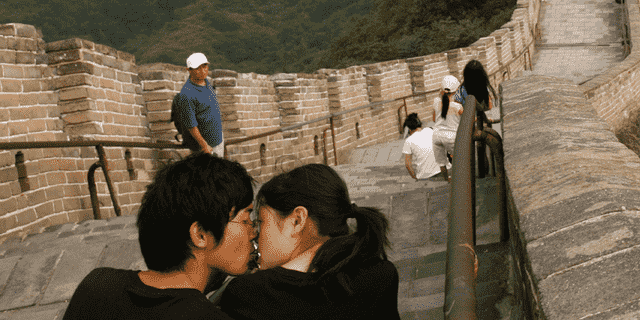 Ein chinesisches Paar küsst sich beim Besuch der Chinesischen Mauer.