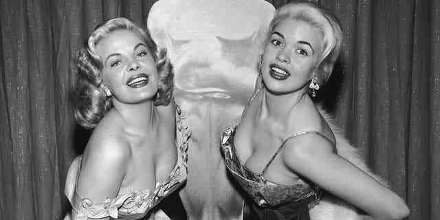 Cleo Moore (links) und Jayne Mansfield posieren vor einem Oscar-Konterfei bei der Oscar-Verleihung um 1956.
