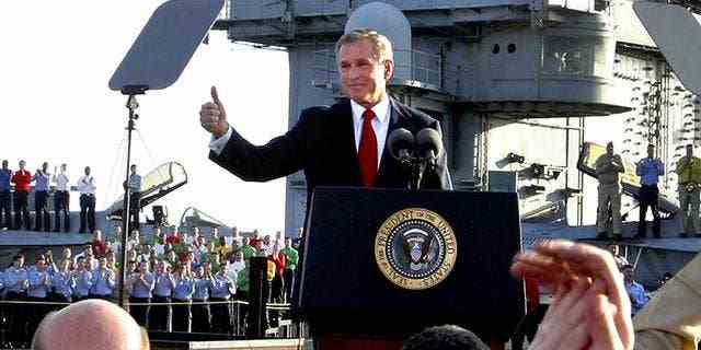 Der frühere Präsident George W. Bush erklärt das Ende der großen Kampfhandlungen im Irak an Bord des Flugzeugträgers USS Abraham Lincoln.  Der Krieg schien damals ein Erfolg zu sein, aber später, als sich die Bedingungen im Irak verschlechterten, wurde die Botschaft von "Mission erfüllt" wurde als verfrüht kritisiert.