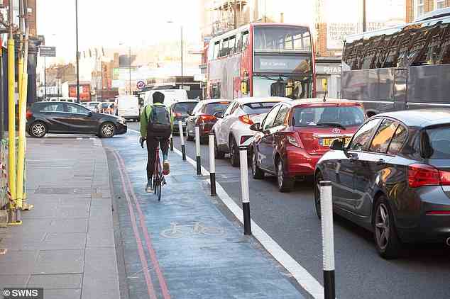 Cars, buses and coaches queue as a cyclist uses a cycle lane on Tooting High Street in South London in September last year