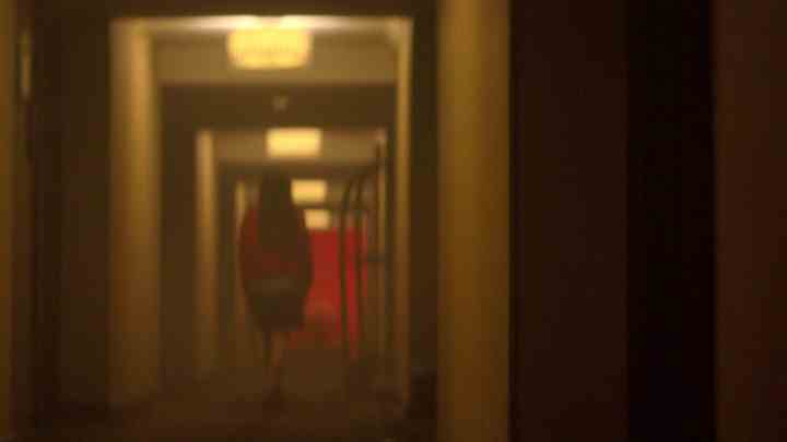 Eine Frau geht in Crime Scene: The Vanishing at Cecil Hotel einen Flur entlang