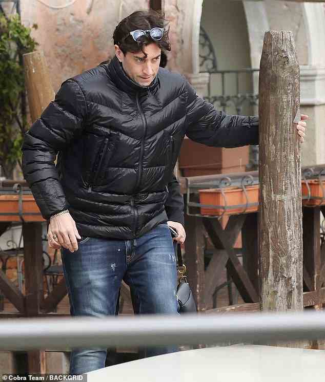 Looking good: James wrapped up in a black padded jacket which he teamed with blue jeans and bright yellow trainers