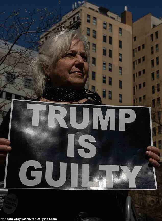 Menschen machen und halten Schilder über den ehemaligen Präsidenten Trump außerhalb des Manhattan Criminal Court, Manhattan, New York