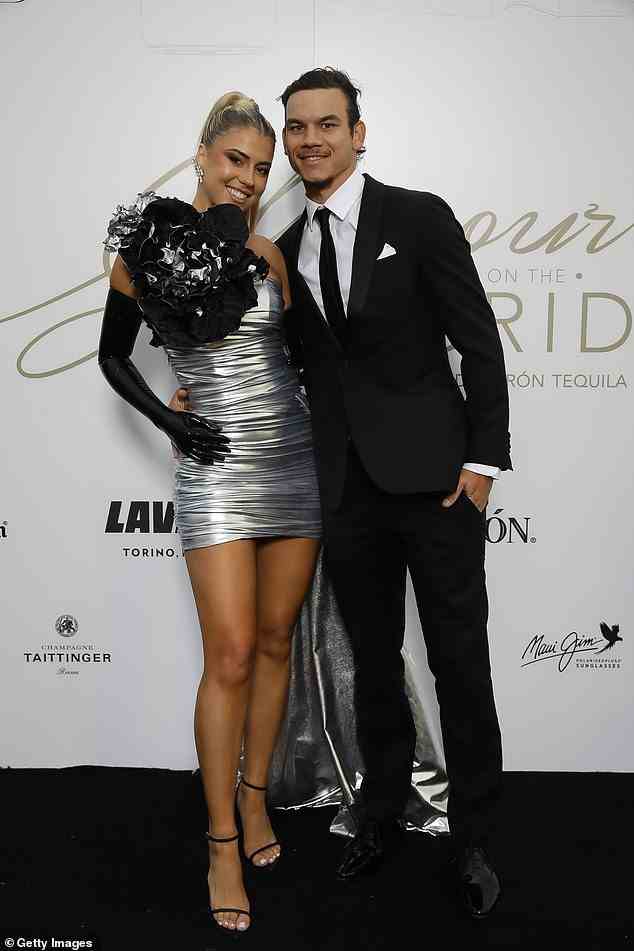 AFL star Daniel Rioli (right) opted for a classic suit while his partner Paris opted for a wow-factor mini dress in silver
