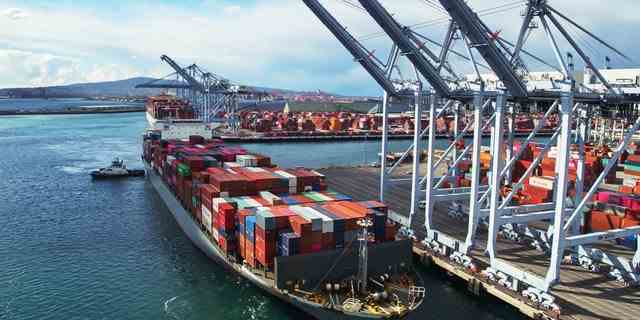 Drohnenaufnahme eines riesigen Containerschiffs, das im Hafen von Long Beach, Kalifornien, ankommt.