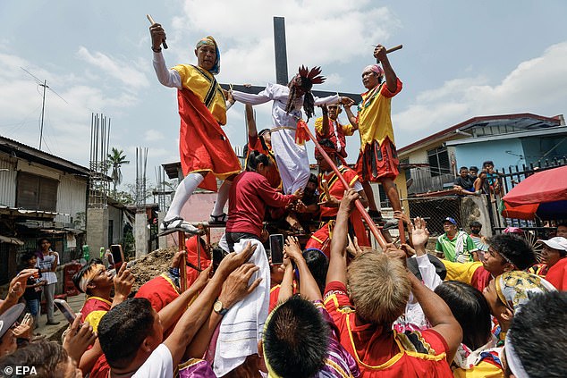 Zuschauer beobachten eine Gruppe katholischer Anhänger, die das Leiden und Sterben Jesu Christi am Gründonnerstag darstellen