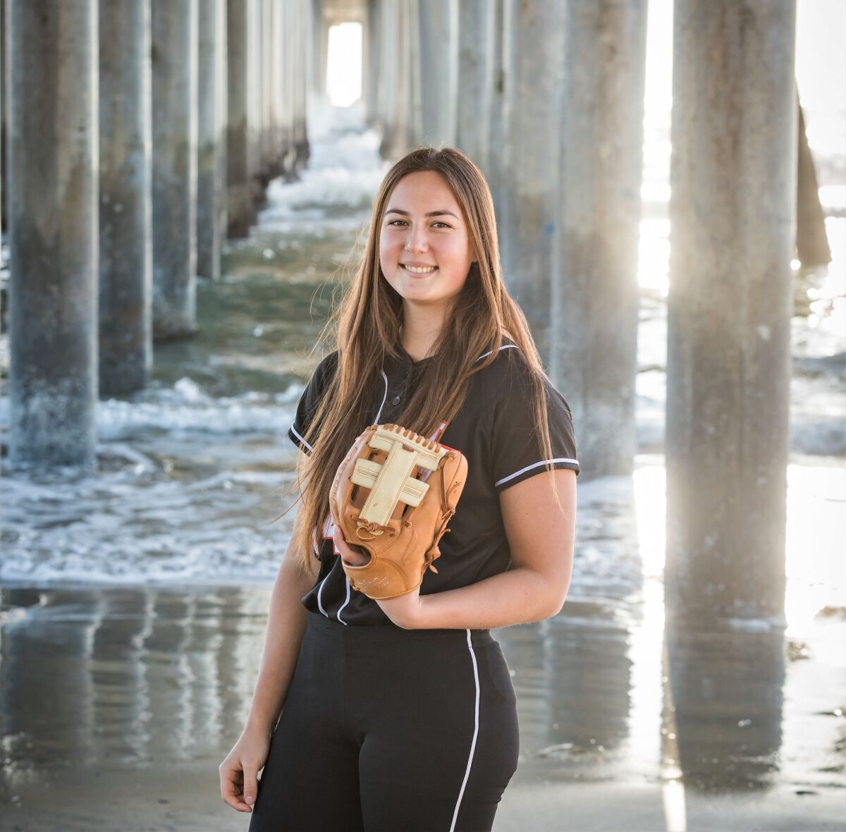 Huntington Beach High Softball Pitcher Zoe Prystajko posiert für ein Foto am Pier.