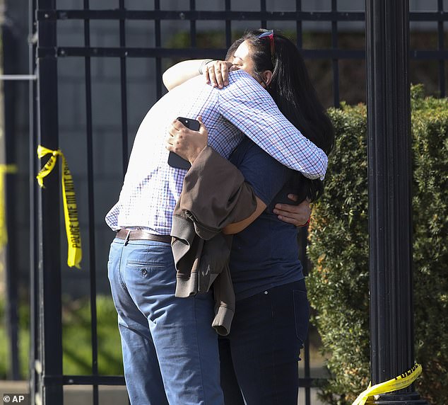 Two people are pictured embracing outside the Old National Bank in Louisville